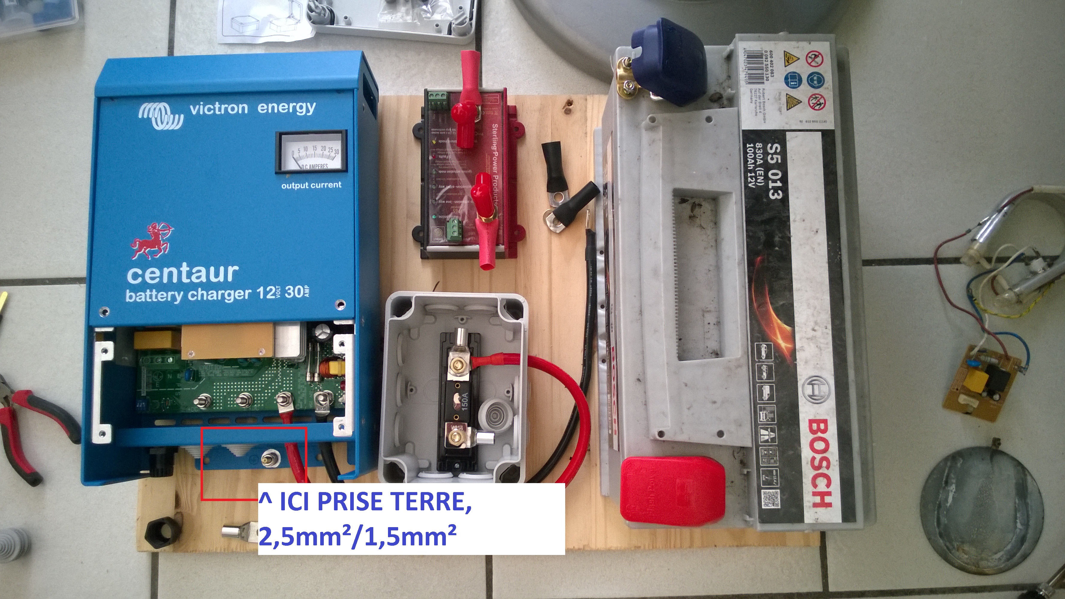 Photo annotée indiquant où brancher la masse de la prise de 
l'onduleur après connexion à la carcasse du chargeur.